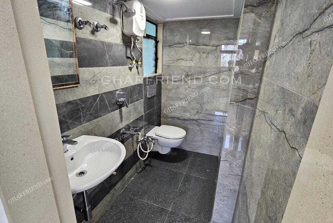 "Modern washroom with premium sanitary fittings, anti-skid flooring, and full-height wall tiles for a sleek and elegant finish.