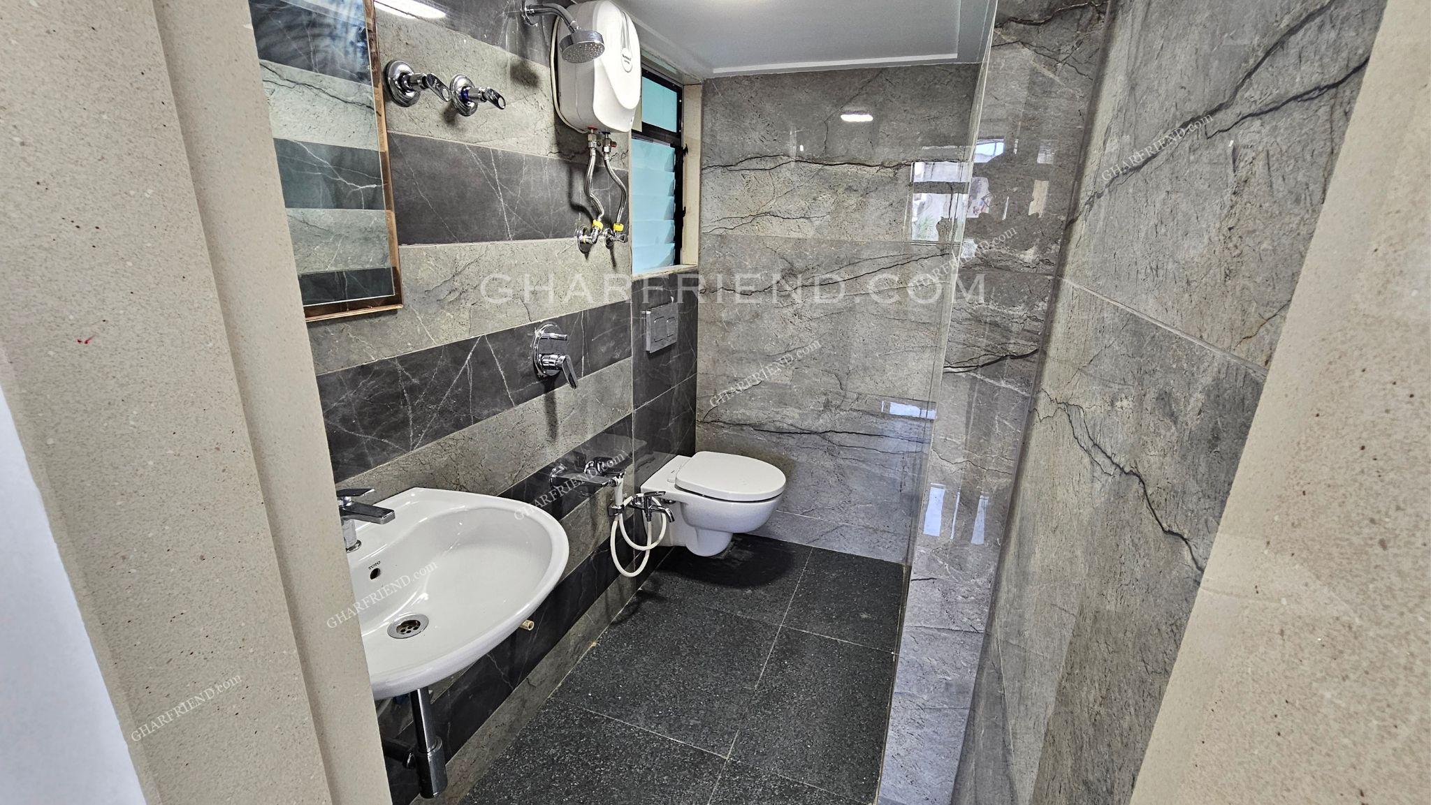 "Modern washroom with premium sanitary fittings, anti-skid flooring, and full-height wall tiles for a sleek and elegant finish.