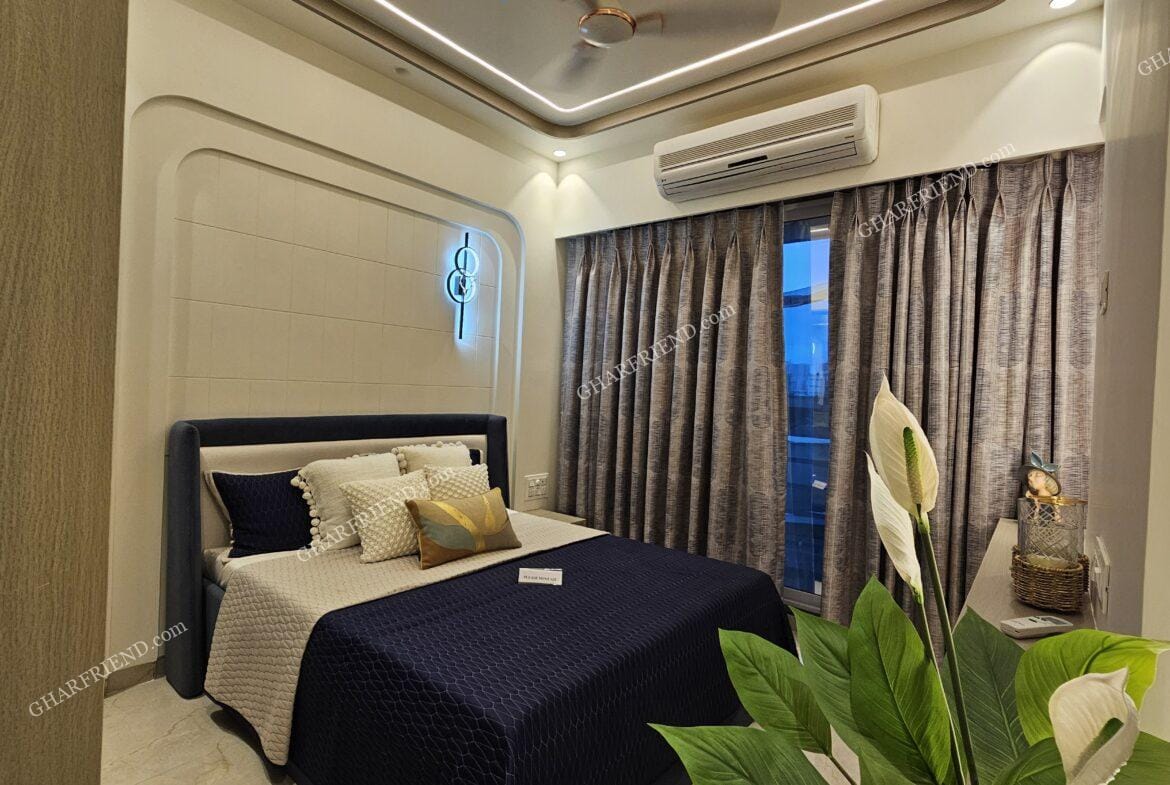 A spacious and well-lit common bedroom in a 1 & 2 BHK apartment at Mira Road, featuring large windows, modern interiors, and ample storage space for a comfortable living experience.