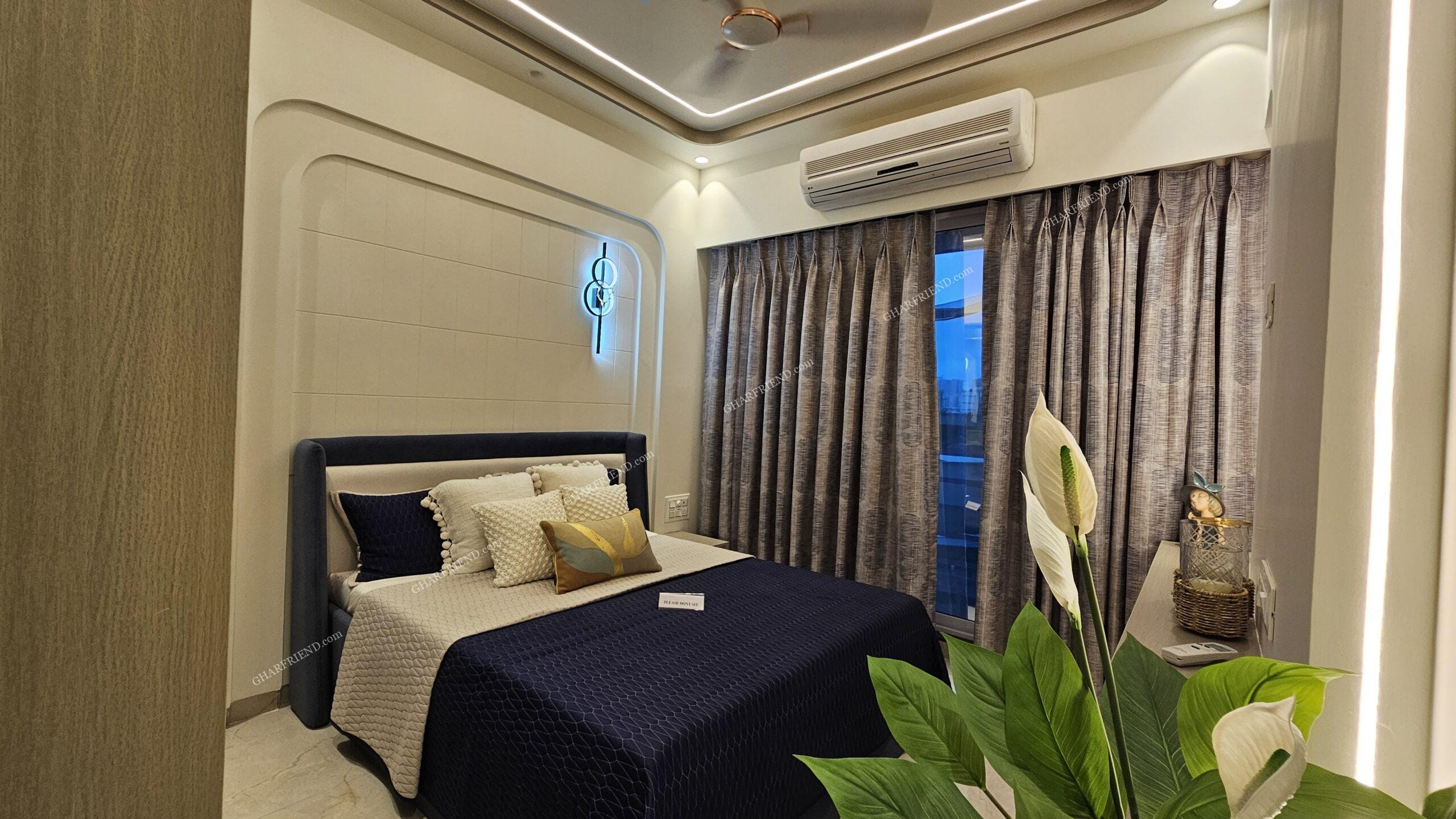 A spacious and well-lit common bedroom in a 1 & 2 BHK apartment at Mira Road, featuring large windows, modern interiors, and ample storage space for a comfortable living experience.